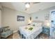 Cozy bedroom featuring a decorative bed, beach artwork, and a ceiling fan at 1490 Mahogany Ln # 706, Palm Harbor, FL 34683