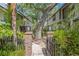 Welcoming brick-paved courtyard entrance between townhomes with lush greenery and mature trees at 1490 Mahogany Ln # 706, Palm Harbor, FL 34683