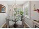 Cozy dining area with round glass table, shuttered windows, and chandelier at 1490 Mahogany Ln # 706, Palm Harbor, FL 34683