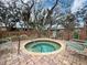A cozy, in-ground hot tub with chairs and brick patio, perfect for relaxation and enjoying the outdoors at 1490 Mahogany Ln # 706, Palm Harbor, FL 34683