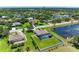 Aerial view of home with screened-in pool, fenced yard, and pond on a lush, green lot at 1603 21St W Ave, Palmetto, FL 34221