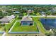 Aerial view of home with fenced-in pool and pond, set in a residential neighborhood with mature trees at 1603 21St W Ave, Palmetto, FL 34221