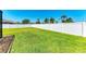A large backyard with green grass surrounded by a white privacy fence provides ample space at 1603 21St W Ave, Palmetto, FL 34221