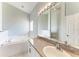 Bathroom with a large soaking tub, vanity with granite countertop, and a large mirror at 1603 21St W Ave, Palmetto, FL 34221