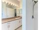 Bathroom with a tiled shower, vanity with granite countertop, and a large mirror at 1603 21St W Ave, Palmetto, FL 34221