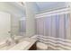 Neutral bathroom with a granite countertop, shower with gray and white striped curtain at 1603 21St W Ave, Palmetto, FL 34221
