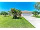 Well-maintained single-story home with a lush green lawn, mature landscaping, and a two-car garage at 1603 21St W Ave, Palmetto, FL 34221