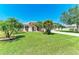 Charming single-story home with lush green lawn, mature palms, and a welcoming driveway at 1603 21St W Ave, Palmetto, FL 34221