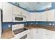 Kitchen with white appliances, brown countertop, and upper cabinets at 1603 21St W Ave, Palmetto, FL 34221