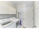 Clean laundry room with modern, white washer and dryer units and white cabinets at 1603 21St W Ave, Palmetto, FL 34221