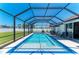 Sparkling screened-in pool with outdoor seating and lush, grassy yard at 1603 21St W Ave, Palmetto, FL 34221