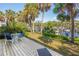 Wooden deck features outdoor seating, views of the harbor, and surrounding palm trees at 1621 Boathouse Cir # 125, Sarasota, FL 34231