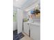 Bright laundry room with white washer and dryer, storage shelves, and access to the outside at 1621 Boathouse Cir # 125, Sarasota, FL 34231