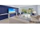 Bright living room features blue accent wall, light wood floors, and sliding doors to the outdoor space at 1621 Boathouse Cir # 125, Sarasota, FL 34231