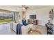 Open living area with a white sofa, decorative accents, and view of the outdoor landscape through sliding doors at 17041 James Trl, Parrish, FL 34219