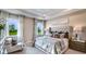 Elegant bedroom with a large bed, tray ceiling, and natural light from the windows at 17917 Tavernside Trl, Lakewood Ranch, FL 34211