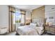 Serene primary bedroom with a large window, stylish decor, a tufted headboard, and a soft, inviting ambiance at 17917 Tavernside Trl, Lakewood Ranch, FL 34211