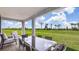 Relaxing covered patio with outdoor furniture overlooking a large, well-maintained lawn and clear blue skies at 17917 Tavernside Trl, Lakewood Ranch, FL 34211