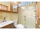 Bathroom featuring a sink, toilet, and stand-up shower with glass doors and yellow walls at 182 Crown Point Dr, Nokomis, FL 34275