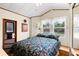 Comfortable bedroom with a floral bedspread, natural light from the window, and functional closet space at 182 Crown Point Dr, Nokomis, FL 34275