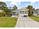 Welcoming yellow home featuring a screen porch, well-manicured lawn, and a paved driveway at 182 Crown Point Dr, Nokomis, FL 34275