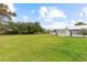 Landscaped exterior view showcasing the well-maintained lawn and surrounding mature trees at 182 Crown Point Dr, Nokomis, FL 34275