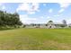 Wide shot of homes with beautiful well maintained lawns under a blue sky with some clouds at 182 Crown Point Dr, Nokomis, FL 34275