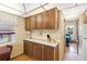Cozy kitchen features wooden cabinets, light countertops, and a window with lace curtains, creating a warm atmosphere at 182 Crown Point Dr, Nokomis, FL 34275