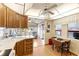 Bright kitchen features a double sink, wooden cabinets, and a dining area, seamlessly connecting to a sunlit living space at 182 Crown Point Dr, Nokomis, FL 34275
