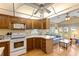 Well-lit kitchen with plentiful cabinetry, white appliances, and an open view into the living space at 182 Crown Point Dr, Nokomis, FL 34275