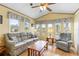 Bright living room featuring a comfortable sofa, armchair, wood laminate floors, and plenty of natural light at 182 Crown Point Dr, Nokomis, FL 34275