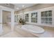 Elegant bathroom with a luxurious soaking tub, plantation shutters, and sleek fixtures for relaxation at 1829 Bougainvillea St, Sarasota, FL 34239