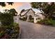 Charming two-story home with Tudor details, beautiful landscaping, and a paved driveway leading to the garage at 1829 Bougainvillea St, Sarasota, FL 34239