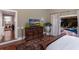 Relaxing main bedroom with hardwood floors, pool access, and a decorative carved-wood dresser at 1829 Bougainvillea St, Sarasota, FL 34239