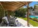 Covered pergola with comfortable seating area overlooking the pool and backyard at 1829 Bougainvillea St, Sarasota, FL 34239