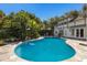 Inviting pool surrounded by lush tropical landscaping and a stone patio at 1829 Bougainvillea St, Sarasota, FL 34239