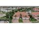 Aerial view of condo in gated community with tile roof, brick driveway, and lush tropical landscaping at 197 Tropicana Dr # 1511, Punta Gorda, FL 33950
