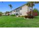 Lush backyard with a manicured lawn, tropical landscaping, and a building view for outdoor enjoyment at 197 Tropicana Dr # 1511, Punta Gorda, FL 33950