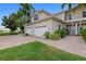 Attractive exterior view of a well-maintained building with a three car garage, vibrant landscaping, and brick driveway at 197 Tropicana Dr # 1511, Punta Gorda, FL 33950