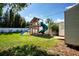 Backyard featuring a playset, storage shed, and lush green grass at 2238 Rose St, Sarasota, FL 34239