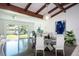 Open concept dining room with view of backyard, hardwood floors, and exposed beams at 2238 Rose St, Sarasota, FL 34239