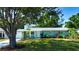 Charming single-story home featuring a well-maintained lawn, mature trees, and colorful landscaping at 2238 Rose St, Sarasota, FL 34239