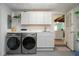 Convenient laundry room with washer, dryer, storage cabinets and white countertop at 2238 Rose St, Sarasota, FL 34239