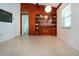 Open room featuring wood paneled wall with built-in shelves, and neutral toned terrazzo flooring at 2238 Rose St, Sarasota, FL 34239