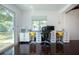 Well-lit home office with dark wood floors, window views, and dual modern white desks at 2238 Rose St, Sarasota, FL 34239