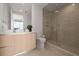 Modern bathroom featuring wood cabinets, marble countertops, and glass-enclosed shower at 301 Quay Commons # 1204, Sarasota, FL 34236