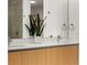 The bathroom has double sinks on a wooden vanity with large mirror and a sleek glass-enclosed shower at 301 Quay Commons # 1204, Sarasota, FL 34236