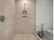 Contemporary shower with tiled walls, a niche for storage, and glass enclosure in the modern bathroom at 301 Quay Commons # 1204, Sarasota, FL 34236