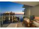 Relaxing balcony seating with amazing views of the water and surrounding city buildings during a colorful dusk at 301 Quay Commons # 1610, Sarasota, FL 34236