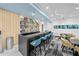 Stylish bar area with blue bar stools, wood shelving, and unique decor at 301 Quay Commons # 1610, Sarasota, FL 34236